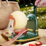 Groene appelschiller met slinger die buiten een appel schilt op een picknickkleed