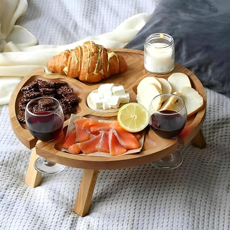 Rond houten picknickwijntafeltje met kaas en wijn op een kleed