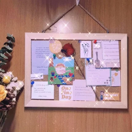 Prikbord van kurk met lichte houten lijst aan de muur met vastgeprikte notities en foto's