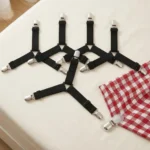 Driehoekige hoeslakenhouders met verstelbare clips op een bed
