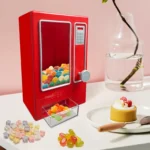 Rode mini-snoepdispenser gevuld met gummies op een tafel
