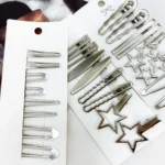 Set van 24 zilverkleurige metalen haarspeldjes, inclusief sterspeldjes, op displaykaartjes